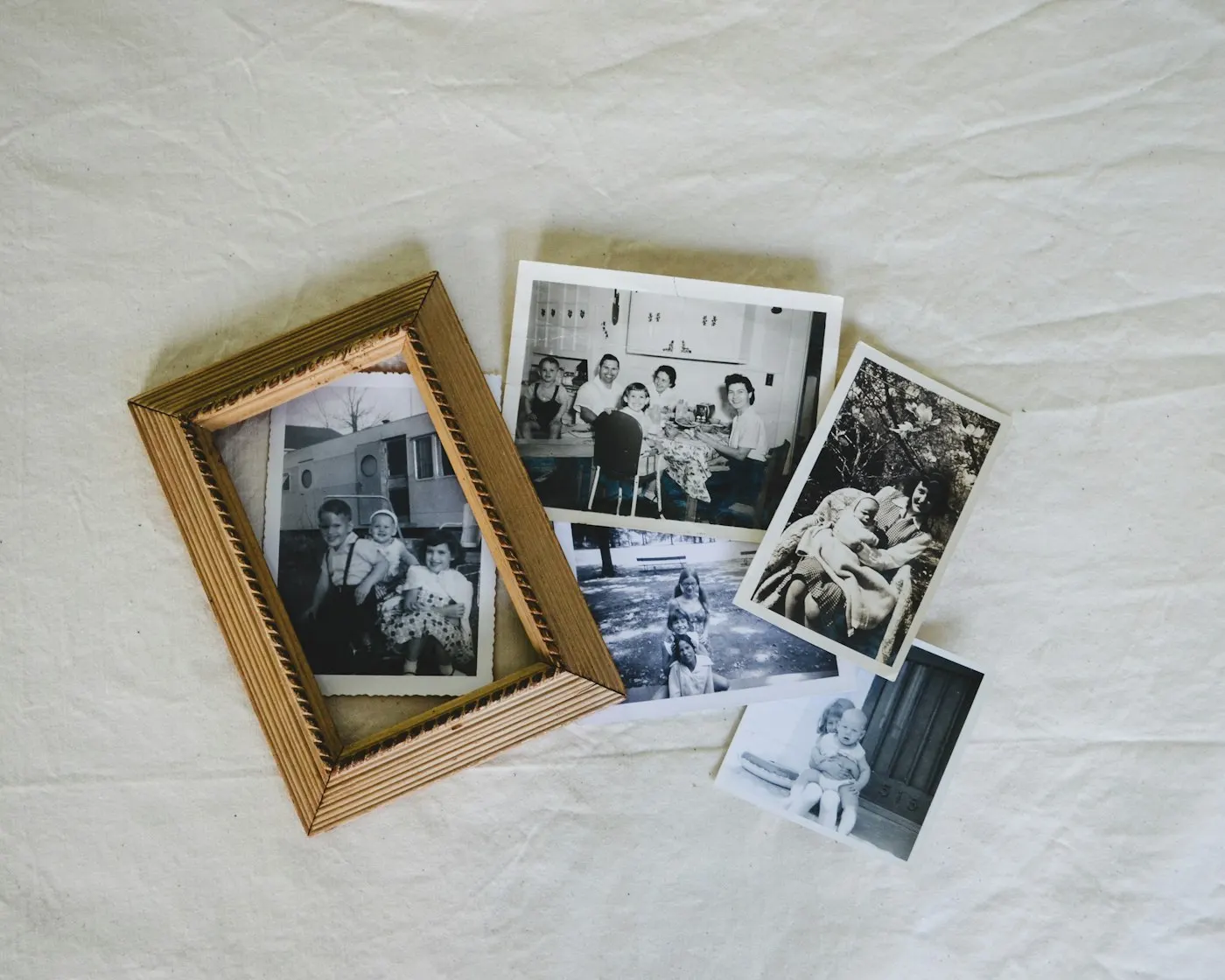 Fotos familiares antiguas en blanco y negro junto a un marco de madera